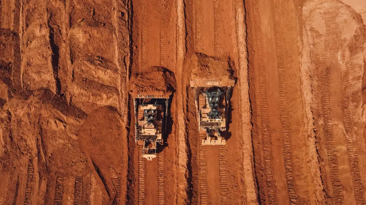 Aerial view of haul trucks on red ground